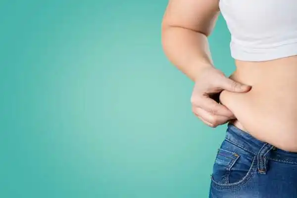 Image of woman pinching her love handles to show weight gain Wibsey